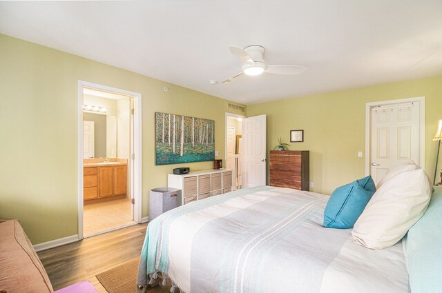 bedroom with light wood-style floors, ceiling fan, ensuite bathroom, and baseboards