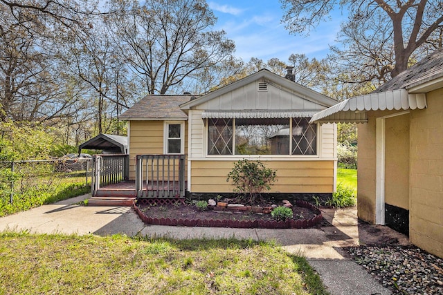 view of front of property with fence, board and batten siding, and a wooden deck