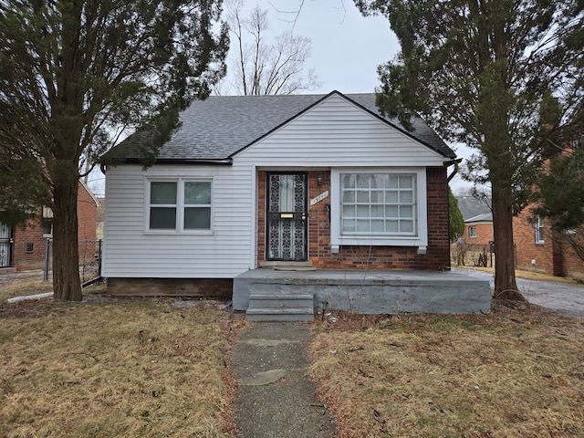 bungalow featuring roof with shingles