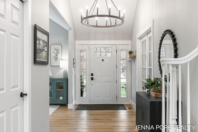 16840 Cricket Ct, Grand Haven, MI 49417 - entryway with vaulted ceiling, wood finished floors, a chandelier, and baseboards
