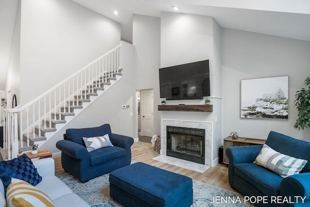 16840 Cricket Ct, Grand Haven, MI 49417 - living room featuring high vaulted ceiling, stairway, wood finished floors, a premium fireplace, and recessed lighting
