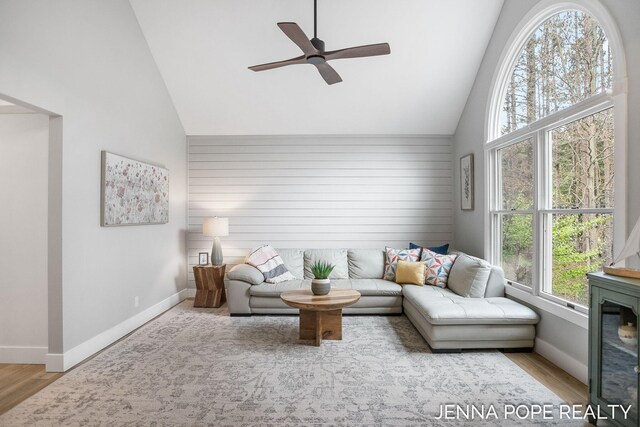 16840 Cricket Ct, Grand Haven, MI 49417 - living room featuring high vaulted ceiling, baseboards, ceiling fan, and wood finished floors