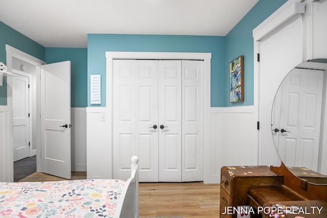 16840 Cricket Ct, Grand Haven, MI 49417 - bedroom featuring light wood finished floors, a wainscoted wall, and a closet