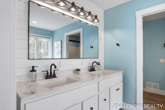 16840 Cricket Ct, Grand Haven, MI 49417 - bathroom featuring double vanity and wood finished floors
