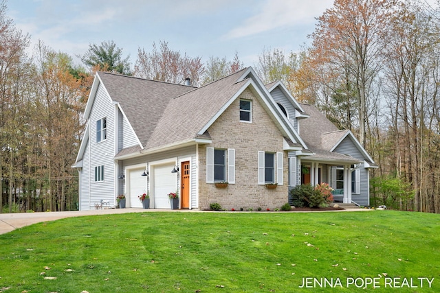 16840 Cricket Ct, Grand Haven, MI 49417 - view of front of house featuring a shingled roof, a front yard, a garage, brick siding, and concrete driveway