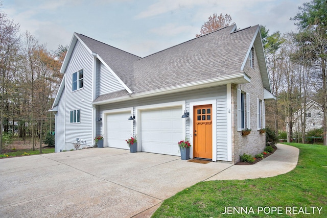 16840 Cricket Ct, Grand Haven, MI 49417 - view of side of home featuring a shingled roof, concrete driveway, an attached garage, stone siding, and a yard