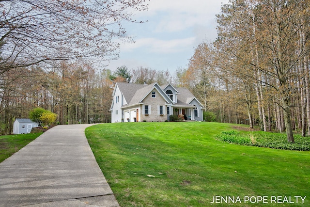 16840 Cricket Ct, Grand Haven, MI 49417 - view of front of home featuring driveway, a front lawn, a storage unit, brick siding, and an outdoor structure