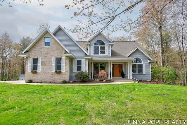 16840 Cricket Ct, Grand Haven, MI 49417 - traditional-style home with covered porch, a front yard, and brick siding