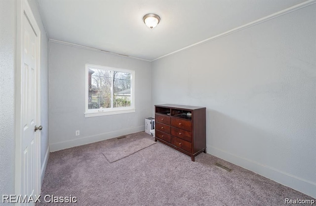 unfurnished bedroom featuring carpet floors, baseboards, and ornamental molding