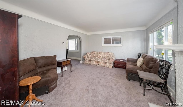 living area with arched walkways and carpet floors