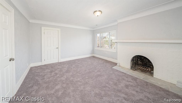 unfurnished living room with carpet flooring, a fireplace with flush hearth, baseboards, and crown molding