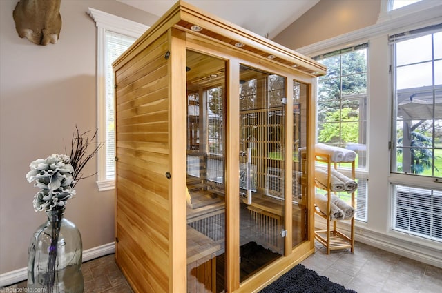 doorway featuring baseboards, healthy amount of natural light, lofted ceiling, and a sauna
