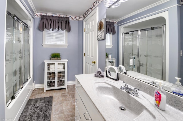 bathroom featuring vanity, ornamental molding, baseboards, and combined bath / shower with glass door