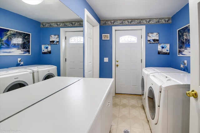 laundry area with washer and clothes dryer and light tile patterned floors