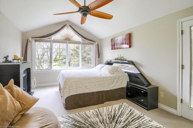 bedroom featuring light colored carpet, baseboards, vaulted ceiling, and ceiling fan
