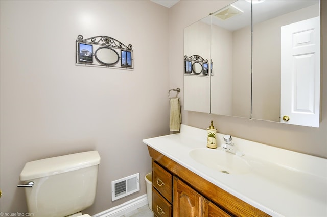 half bath featuring toilet, vanity, and baseboards