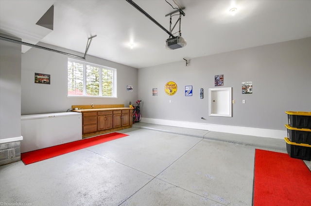 garage with a garage door opener and baseboards