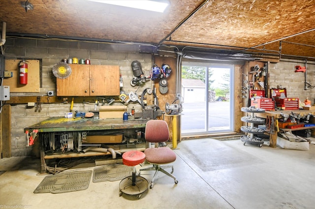 basement featuring a workshop area and concrete block wall