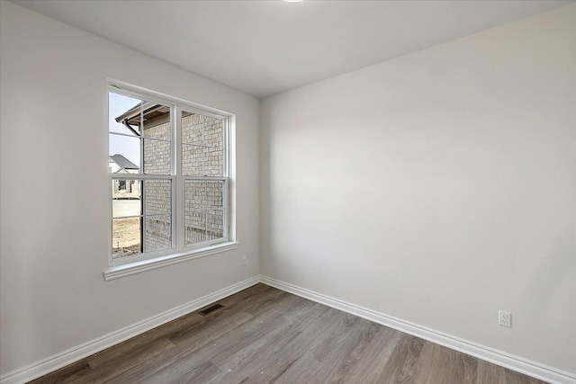 unfurnished room featuring wood finished floors and baseboards