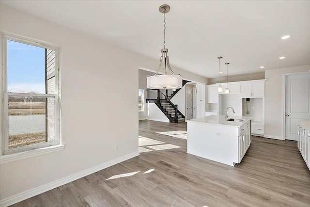 kitchen with healthy amount of natural light, a sink, hanging light fixtures, baseboards, and recessed lighting