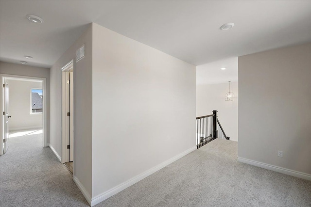 corridor featuring carpet floors, an upstairs landing, recessed lighting, and baseboards
