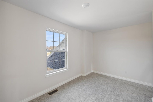 empty room featuring carpet flooring and baseboards