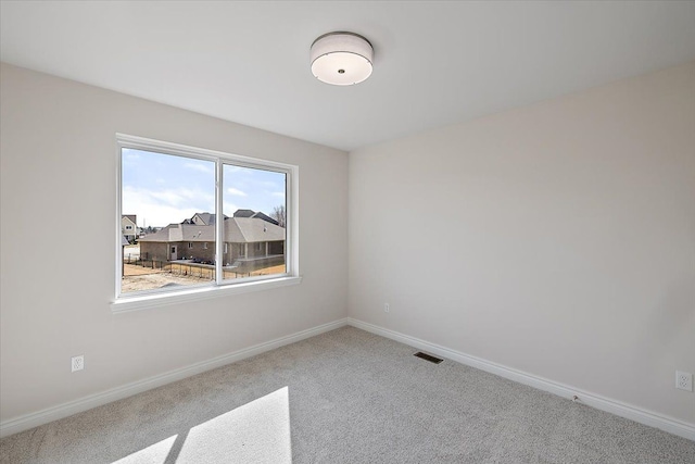 unfurnished room featuring carpet and baseboards