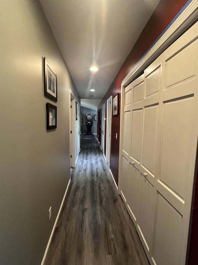 corridor with dark wood-style flooring and baseboards