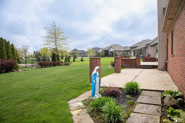 view of yard featuring a patio and a residential view