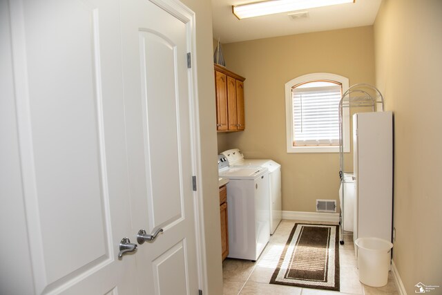 laundry area with cabinet space, washer and clothes dryer, light tile patterned flooring, and baseboards
