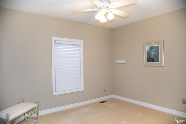 empty room with light carpet, ceiling fan, and baseboards