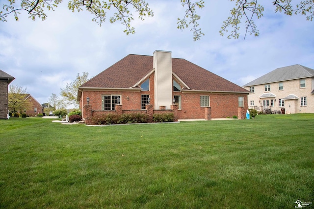 back of house with brick siding, a yard, and a chimney