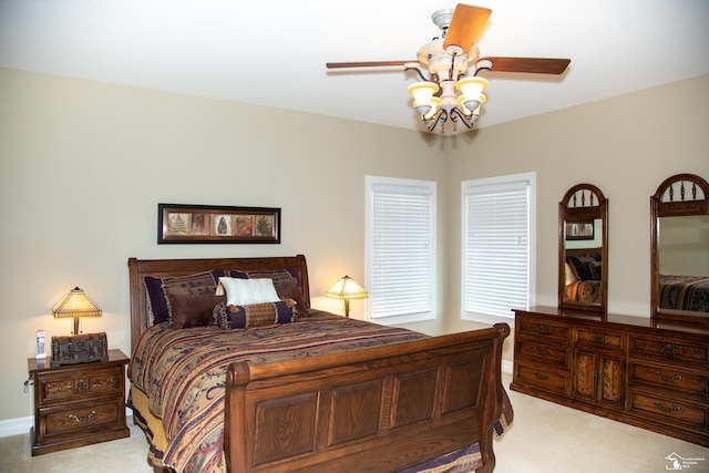 bedroom with light colored carpet, ceiling fan, and baseboards