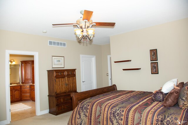 bedroom with light colored carpet, ceiling fan, connected bathroom, and baseboards