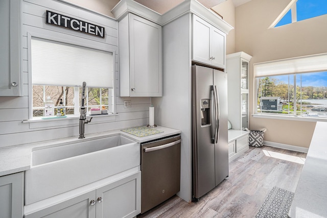 7379 Wimpole Dr NE, Belding, MI 48809 - kitchen featuring appliances with stainless steel finishes, light wood-type flooring, a sink, baseboards, and white cabinetry