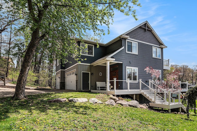 7379 Wimpole Dr NE, Belding, MI 48809 - rear view of house featuring an attached garage, concrete driveway, a lawn, and a porch