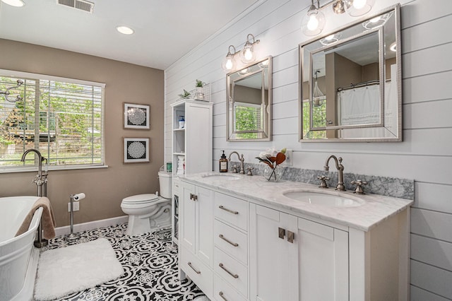 7379 Wimpole Dr NE, Belding, MI 48809 - full bath with toilet, baseboards, double vanity, a soaking tub, and tile patterned floors