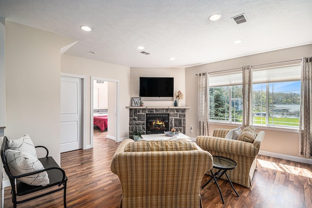 7379 Wimpole Dr NE, Belding, MI 48809 - living room with baseboards, wood finished floors, a fireplace, recessed lighting, and a textured ceiling