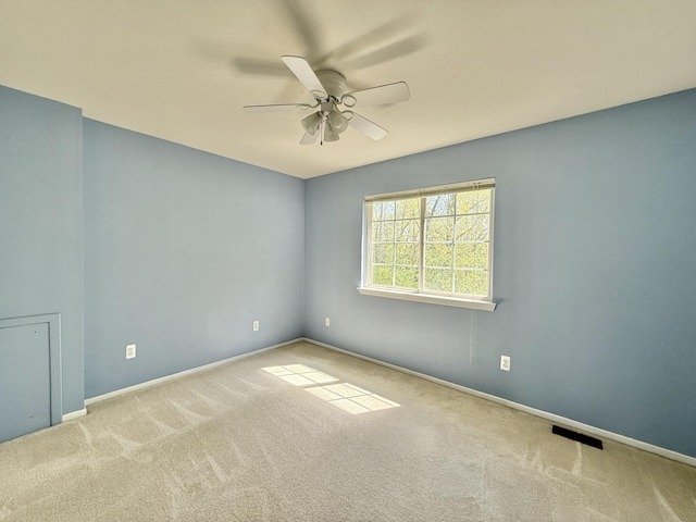 empty room with carpet, ceiling fan, and baseboards