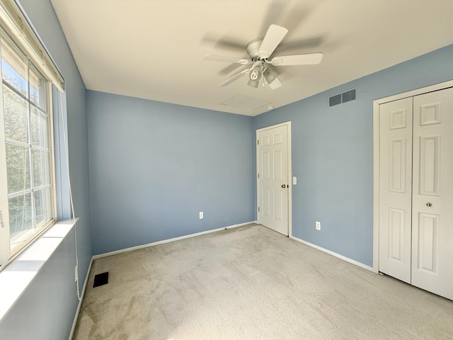 unfurnished bedroom featuring carpet floors, baseboards, ceiling fan, and a closet