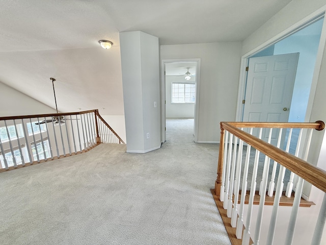 corridor featuring an upstairs landing, carpet flooring, and baseboards