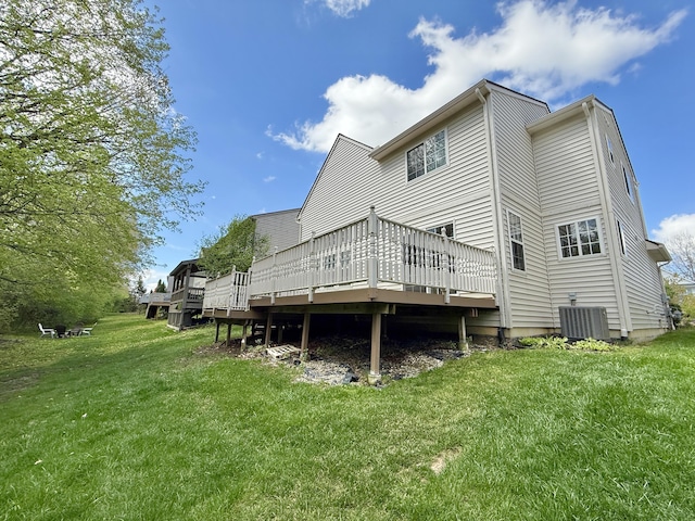 rear view of property with a wooden deck, a lawn, and cooling unit