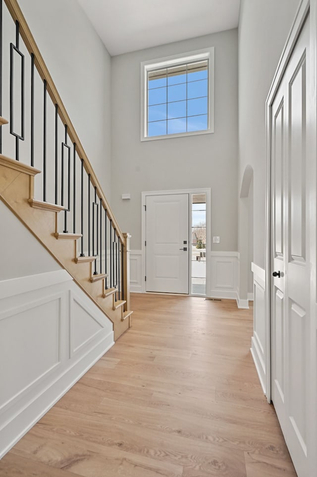 53302 Zachary Dr, Chesterfield, MI 48047 - foyer entrance with stairs, arched walkways, light wood-style floors, a towering ceiling, and a decorative wall