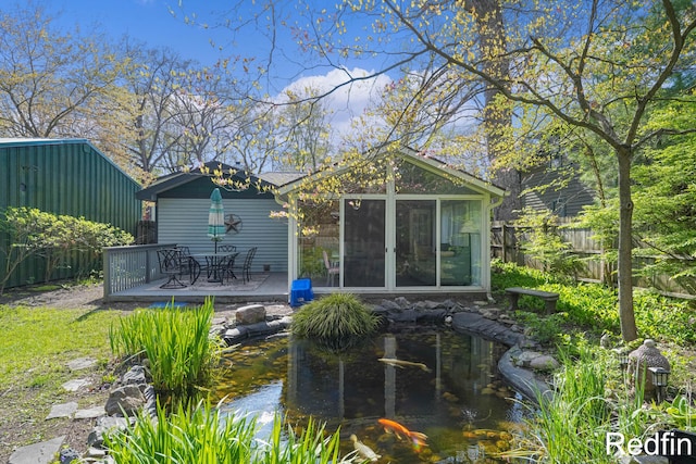16153 Krob Rd, Union Pier, MI 49129 - rear view of property featuring a small pond, a sunroom, and a wooden deck