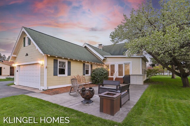 223 E Savidge St, Spring Lake, MI 49456 - view of front of house with a front lawn, a fire pit, roof with shingles, driveway, and a garage