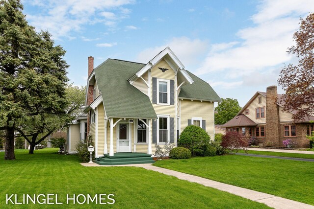 223 E Savidge St, Spring Lake, MI 49456 - view of front of house featuring a front yard and a chimney