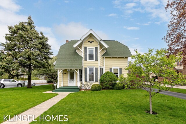 223 E Savidge St, Spring Lake, MI 49456 - view of front facade with a front lawn, a chimney, and roof with shingles