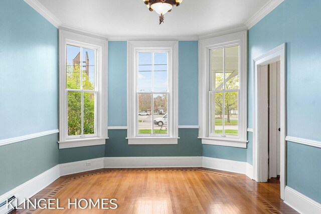 223 E Savidge St, Spring Lake, MI 49456 - unfurnished dining area with ornamental molding, wood finished floors, a baseboard radiator, and baseboards