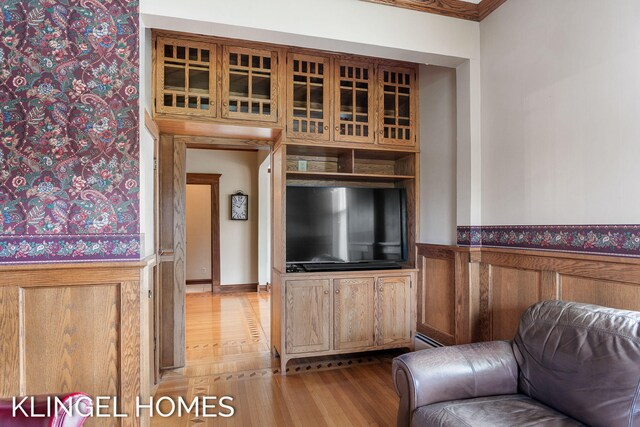 223 E Savidge St, Spring Lake, MI 49456 - living room featuring light wood-style flooring, a baseboard heating unit, and a wainscoted wall