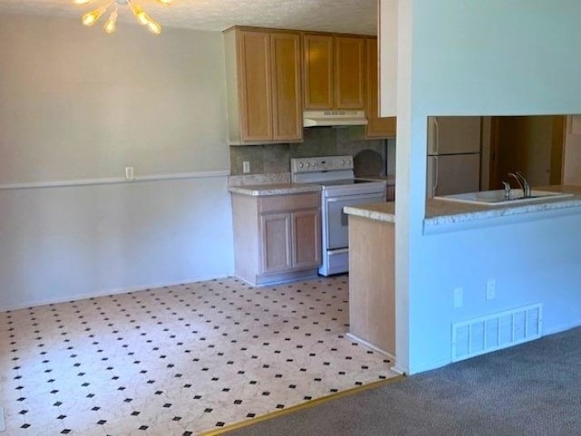 9455 N Parkwood Dr, Davison, MI 48423 - kitchen with white electric stove, under cabinet range hood, light countertops, backsplash, and a sink